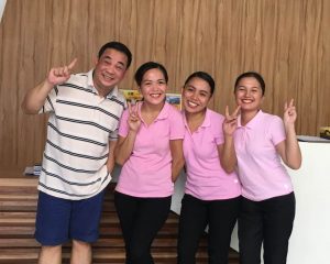General Manager of Ferra Hotels with three Hospitality Students wearing pink shirts