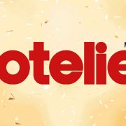 Logo for the online publication Hotelier Middle East, cream background with Hotelier Text in Red
